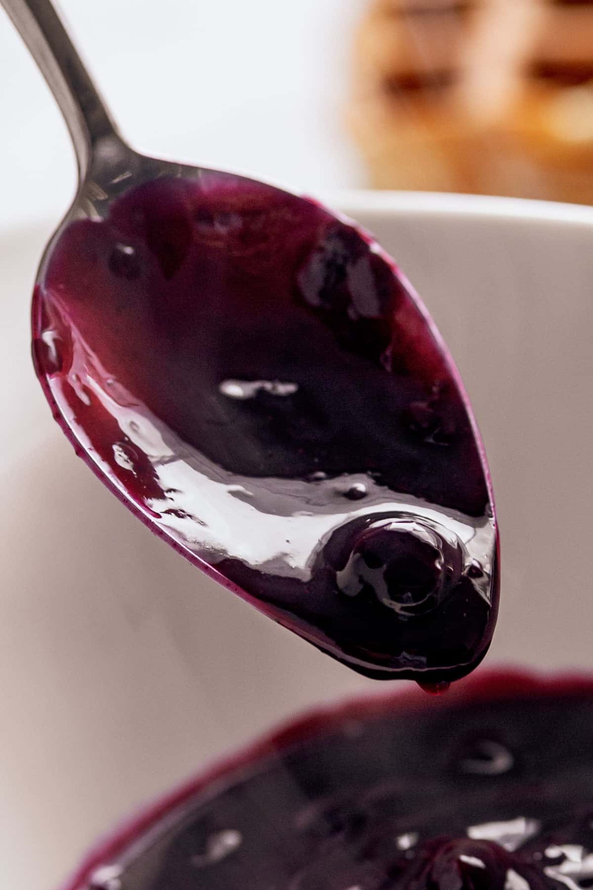 Blueberry Sauce on a metal spoon. close up image. | craveitall.com