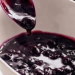 Blueberry Sauce served in a white bowl with a metal spoon | craveitall.com