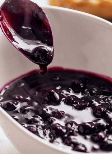 Blueberry Sauce served in a white bowl with a metal spoon | craveitall.com