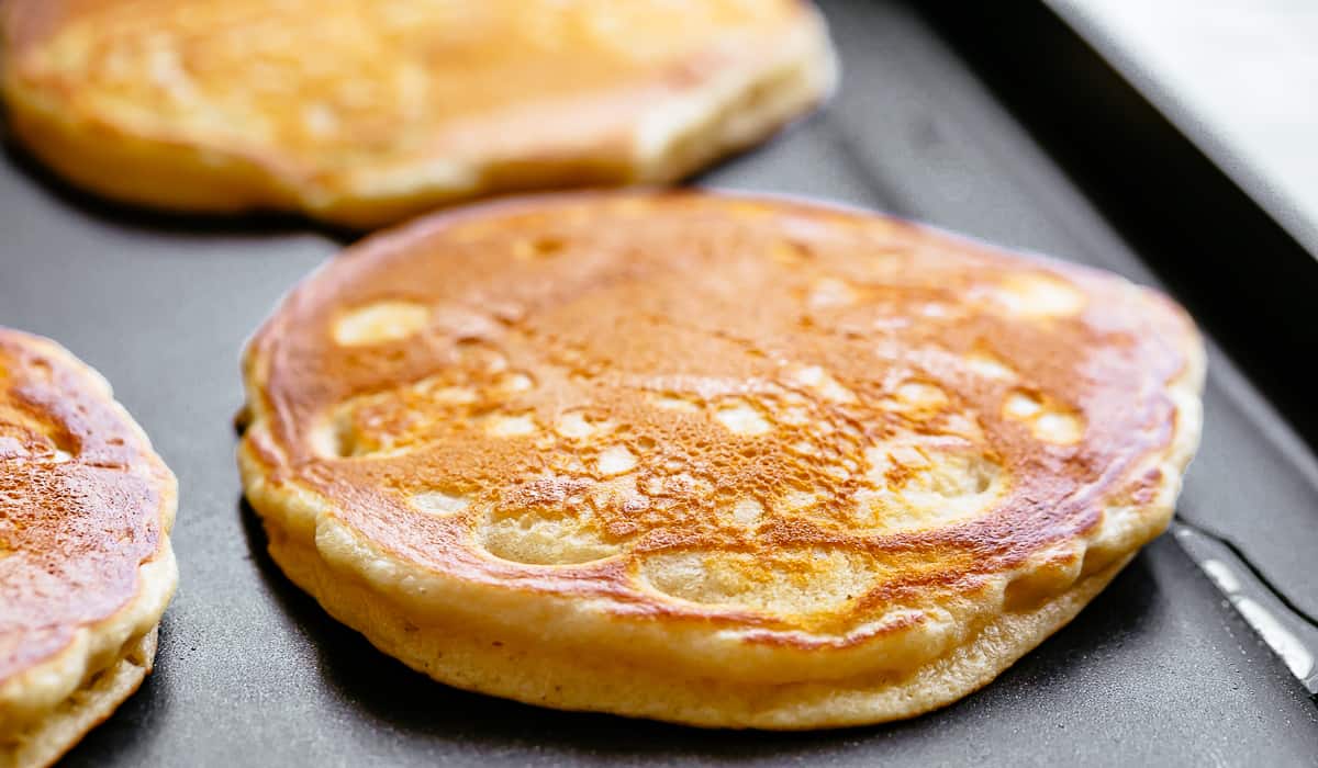 Cooking fluffy pancakes on a lightly greased nonstick griddle.