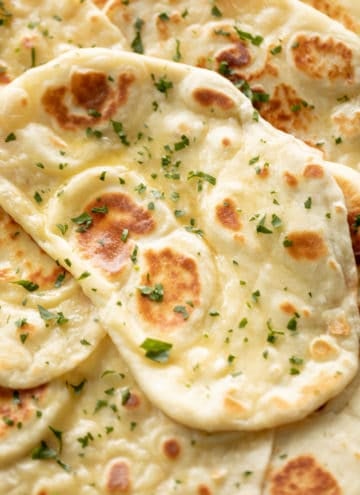 Naan bread brushed with garlic butter and topped with fresh chopped cilantro | craveitall.com