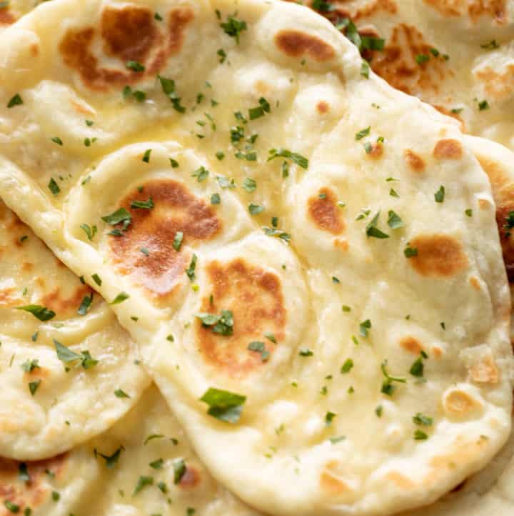 Naan bread brushed with garlic butter and topped with fresh chopped cilantro | craveitall.com