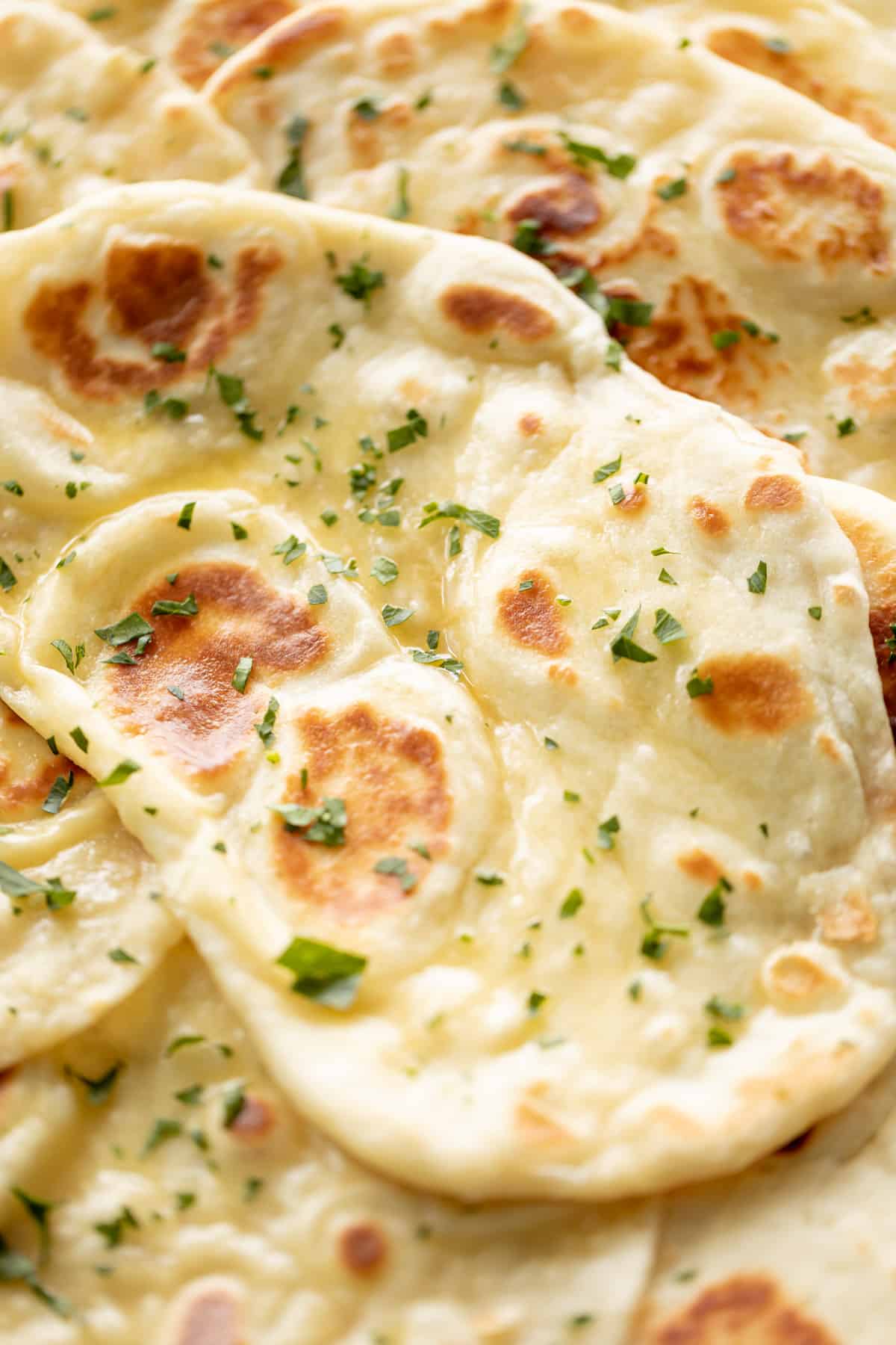 Naan bread brushed with garlic butter and topped with fresh chopped cilantro | craveitall.com